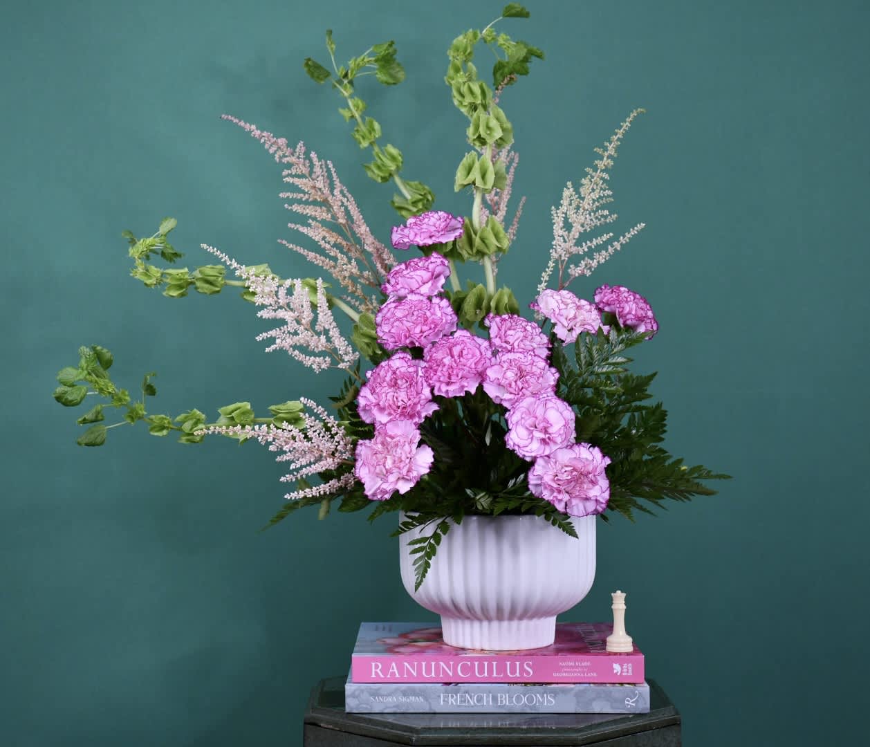 Pink carnations in a white vase with airy pink filler flowers