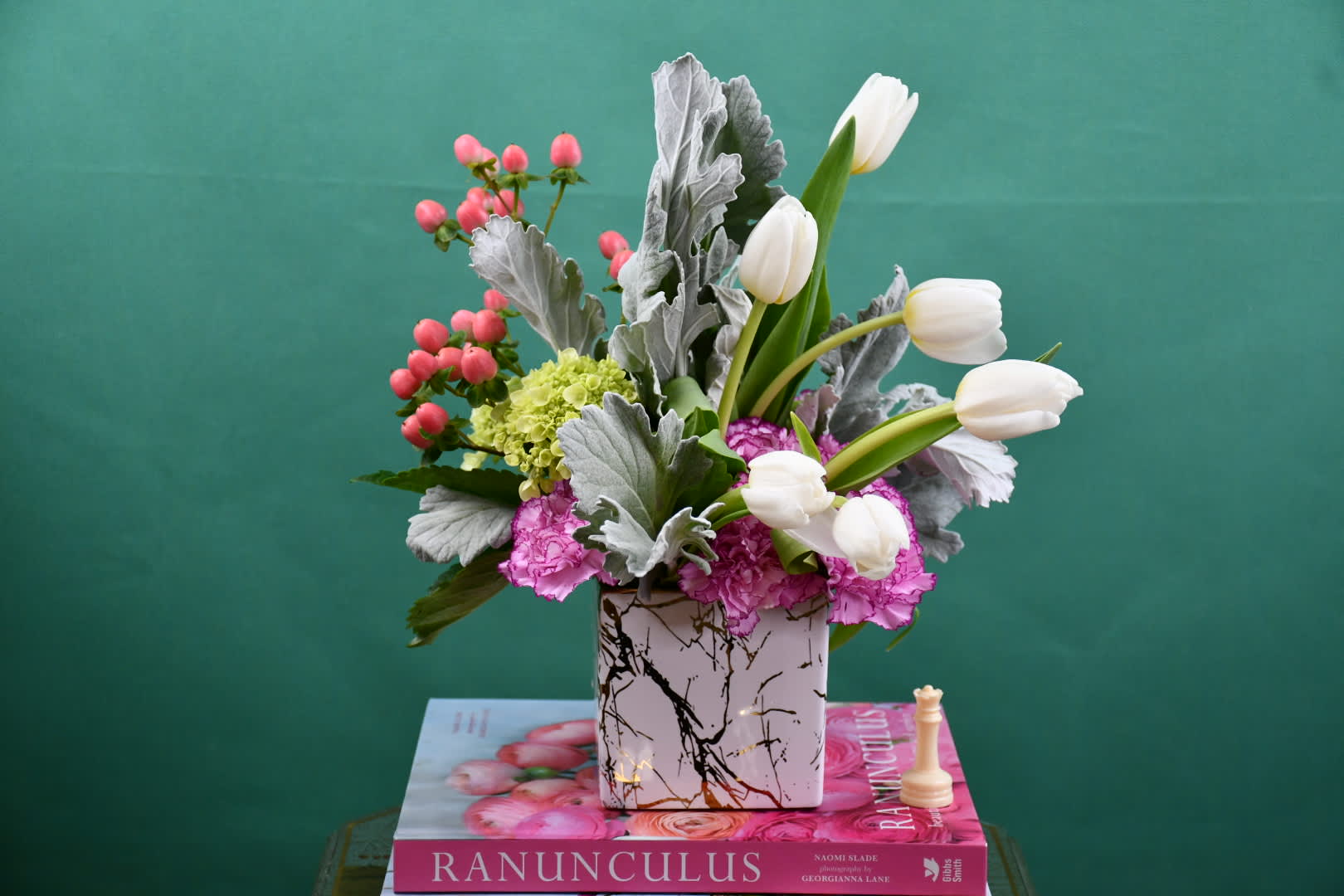 White tulips and pink flowers in a patterned square vase