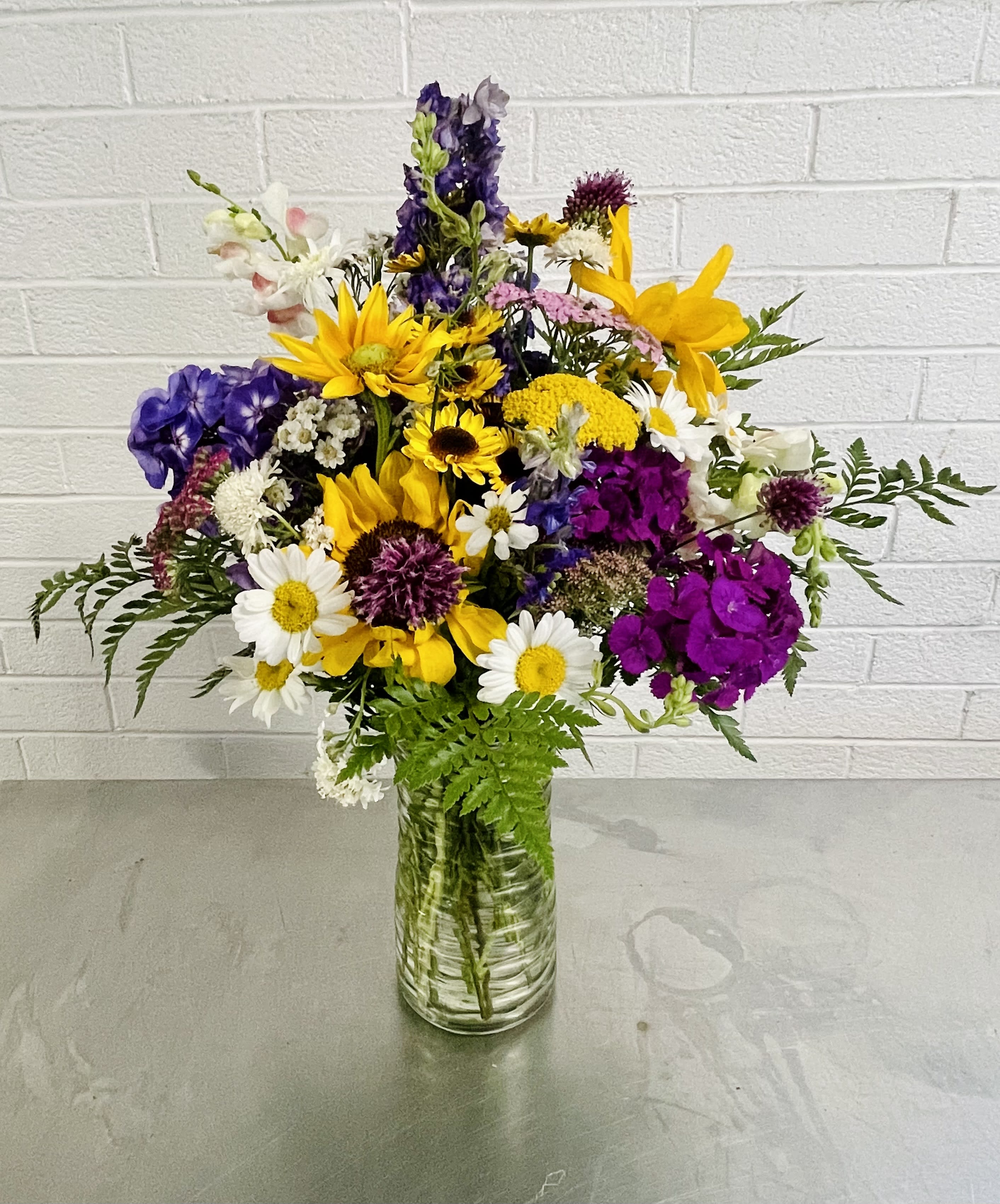Wildflower Bouquet - This colorful vase features a variety of our weekly local wildflowers. Can vary slightly in size and shape based on what is available.
