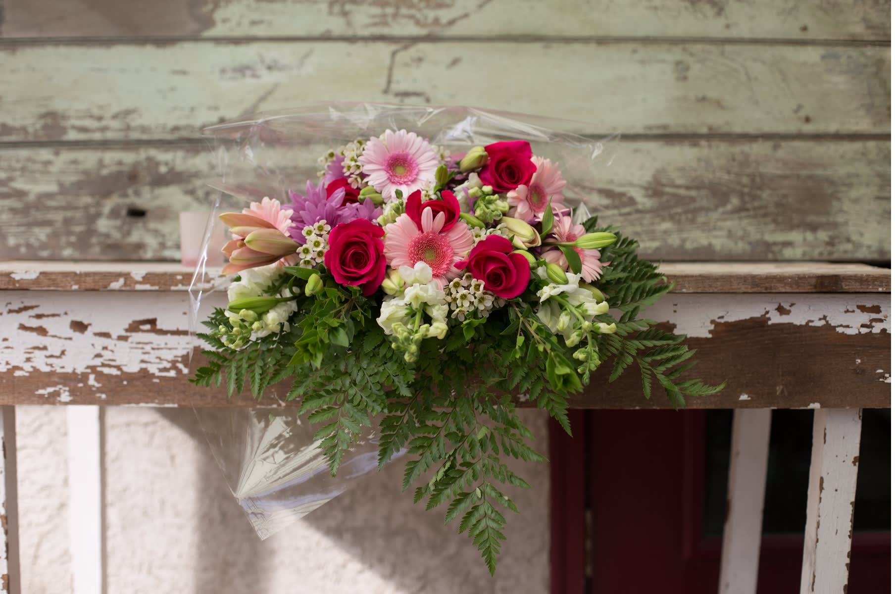 Mixed bouquet of pink and white flowers wrapped in clear plastic