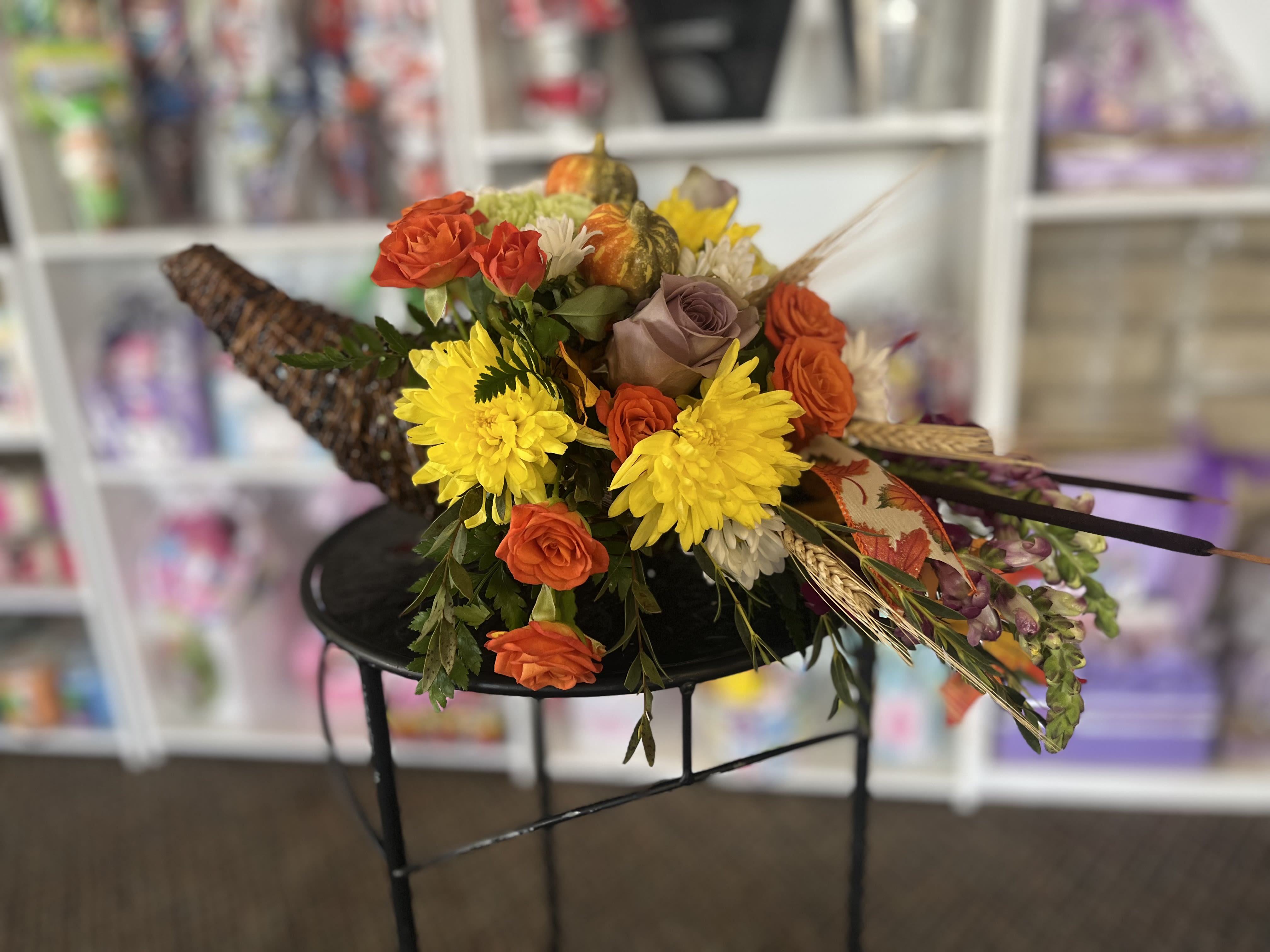 Bouquet of orange and yellow flowers with decorative gourds
