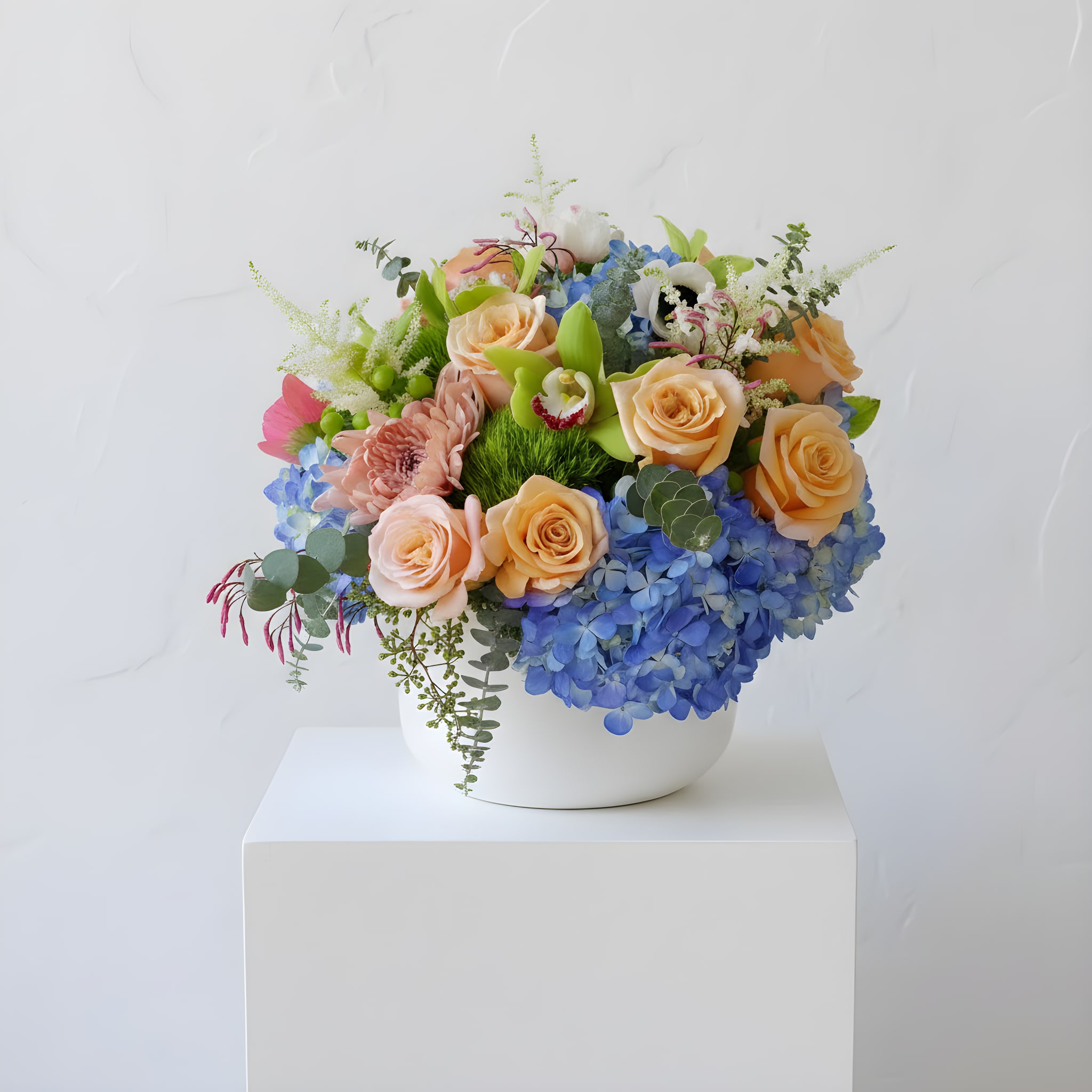 Spring has Sprung  - Serene hues of blue, paired with warm tones of orange mark the transition from winter to spring in this stunning arrangement. 