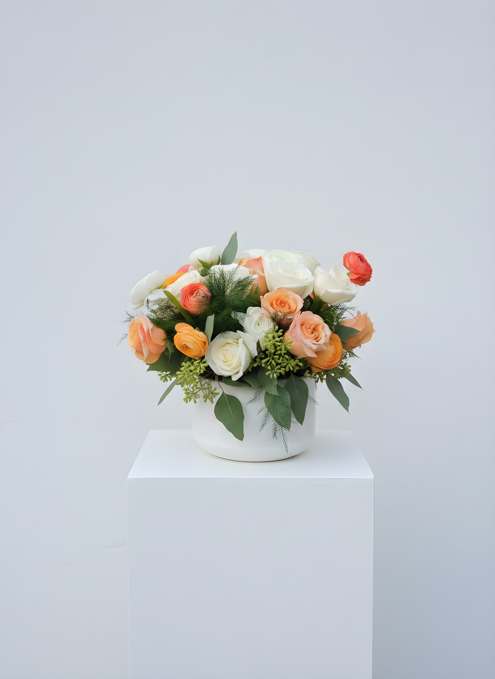 Peaches and Cream - Peach and cream roses and ranunculus mingle in a lush, rounded cluster-an inviting everyday arrangement perfect as a birthday bouquet, anniversary gift, or a cheerful "thinking of you" surprise. The soft peach, orange, pink and white palette reads fresh and romantic; the overall feel is bright and gentle so the person you're sending it to will feel warmly celebrated.