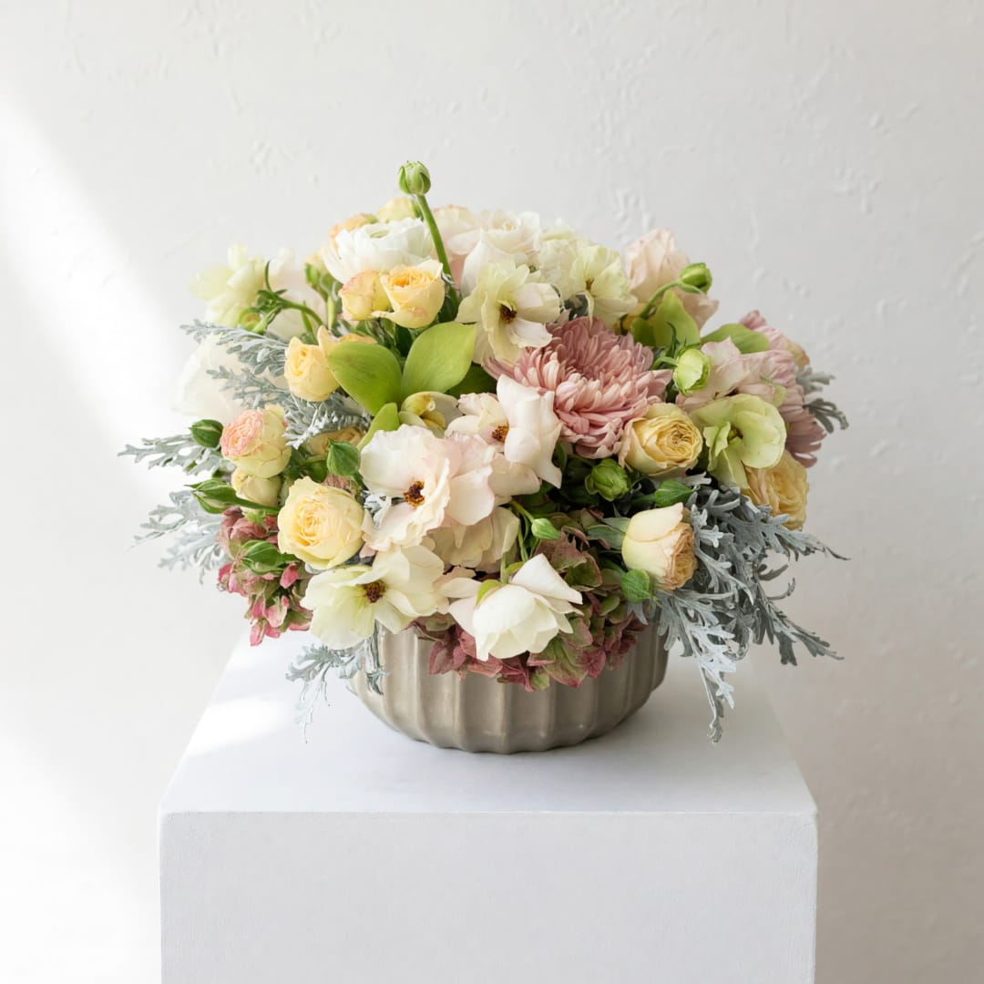Pastel flower arrangement in a ribbed metal bowl