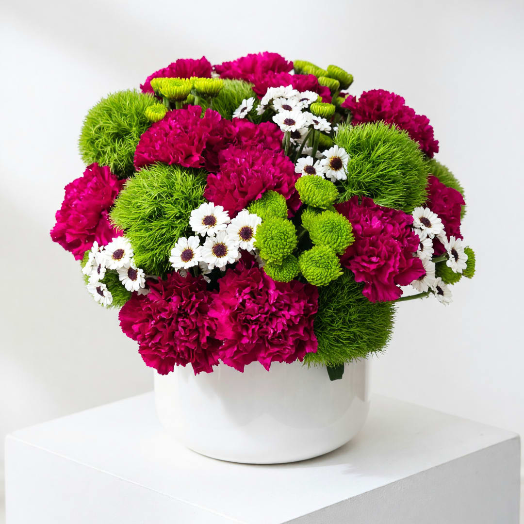 Magenta and green mixed bouquet in a white vase