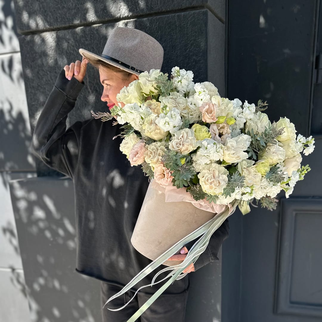Large bouquet of white and blush flowers in a beige hatbox
