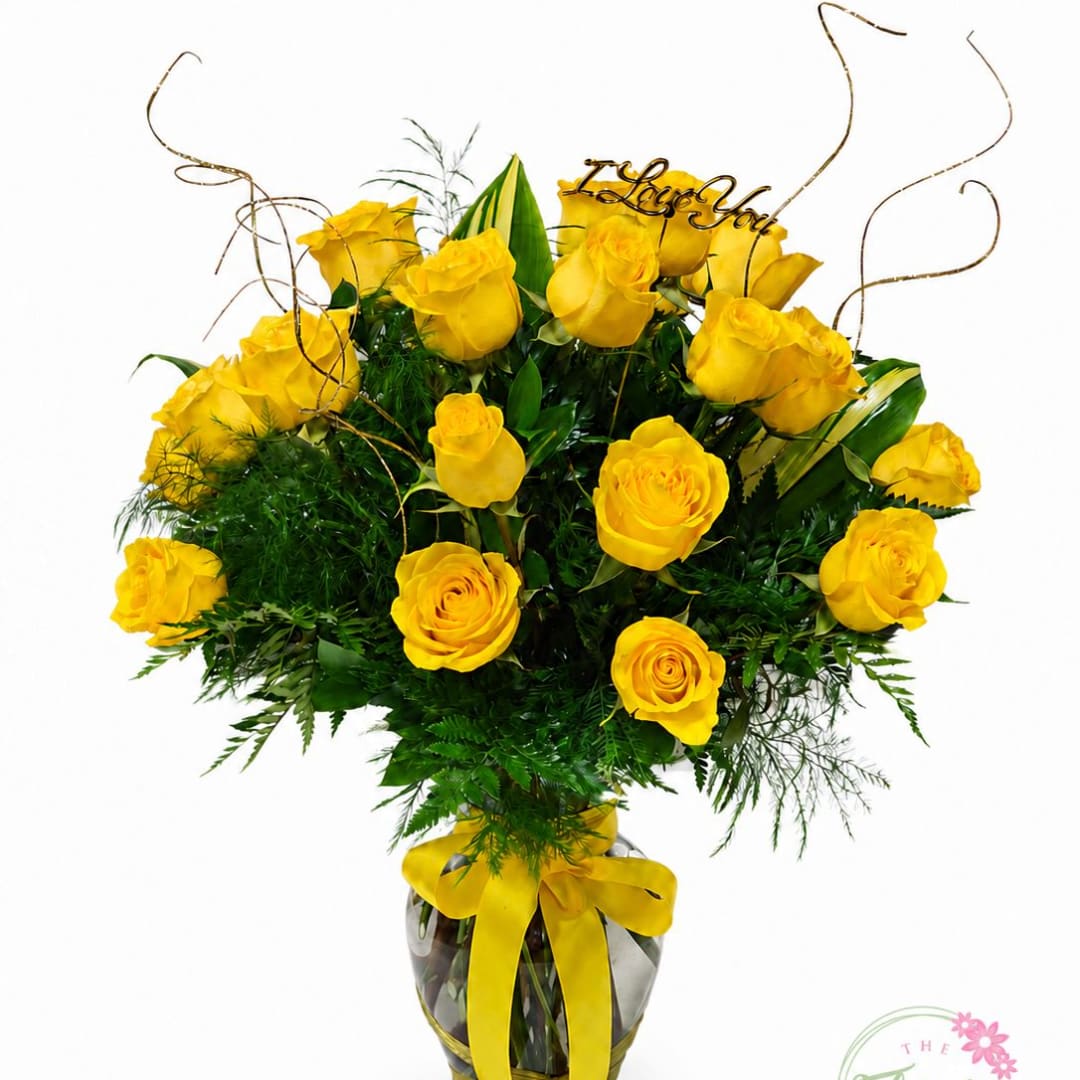 Yellow roses arranged in a glass vase with a ribbon and "I Love You" topper