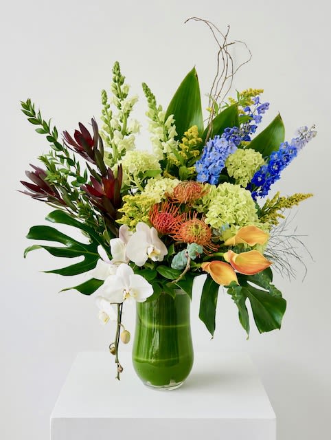 Elevated Harmony - A large, tall arrangement featuring a refined blend of seasonal blooms and lush greenery, designed with balance and movement. Its harmonious palette offers a versatile expression—perfect for both meaningful sympathy and everyday occasions.
