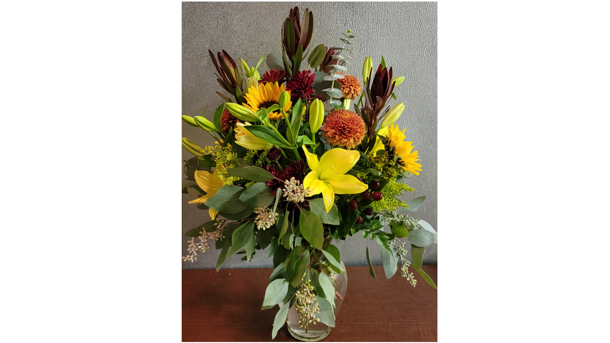 Elegance of Autumn - Yellow lilies, safari sunset, roses and a beautiful assortment of mixed greenery.