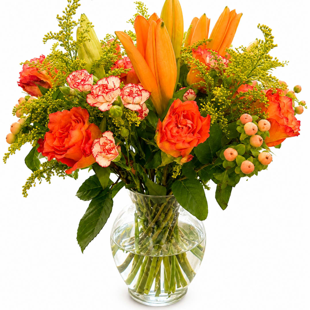 Orange lilies and roses in a clear glass vase