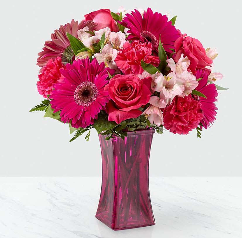 Raspberry Rush™ Bouquet- VASE INCLUDED - The Raspberry Rush™ Bouquet blushes with incredible color to send bright beauty and bold style straight to your special recipient today! Set to capture their every attention, this fresh flower arrangement brings together hot pink roses, hot pink gerbera daisies, and hot pink carnations with pops of soft pink Peruvian Lilies and lush greens to create a bouquet that is simply unforgettable. vase will vary