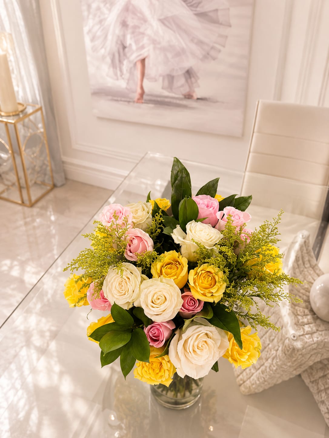 Bouquet of pink, white, and yellow roses in a clear glass vase