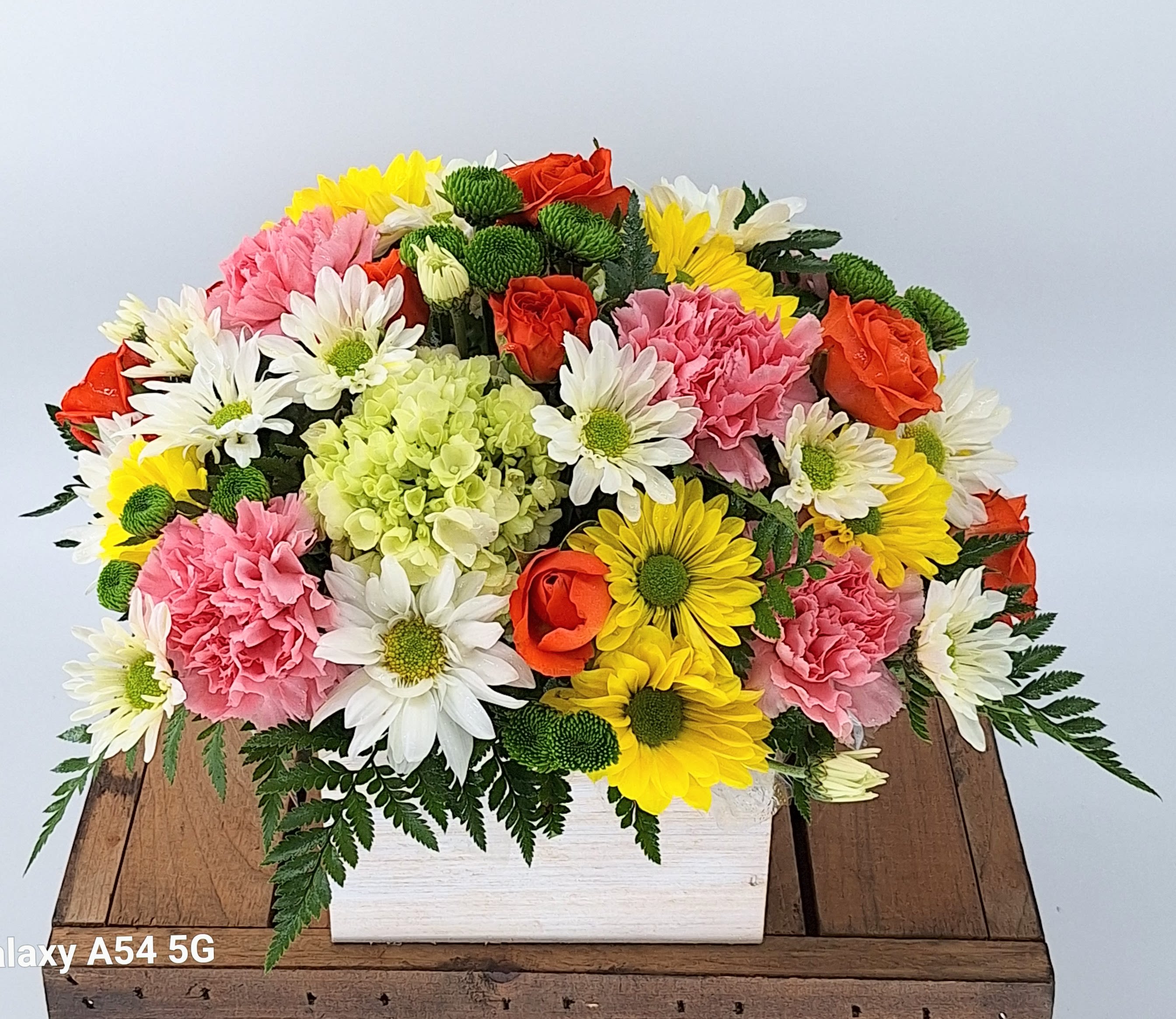 Mixed bouquet in a white rectangular box with roses, carnations, daisies, and chrysanthemums