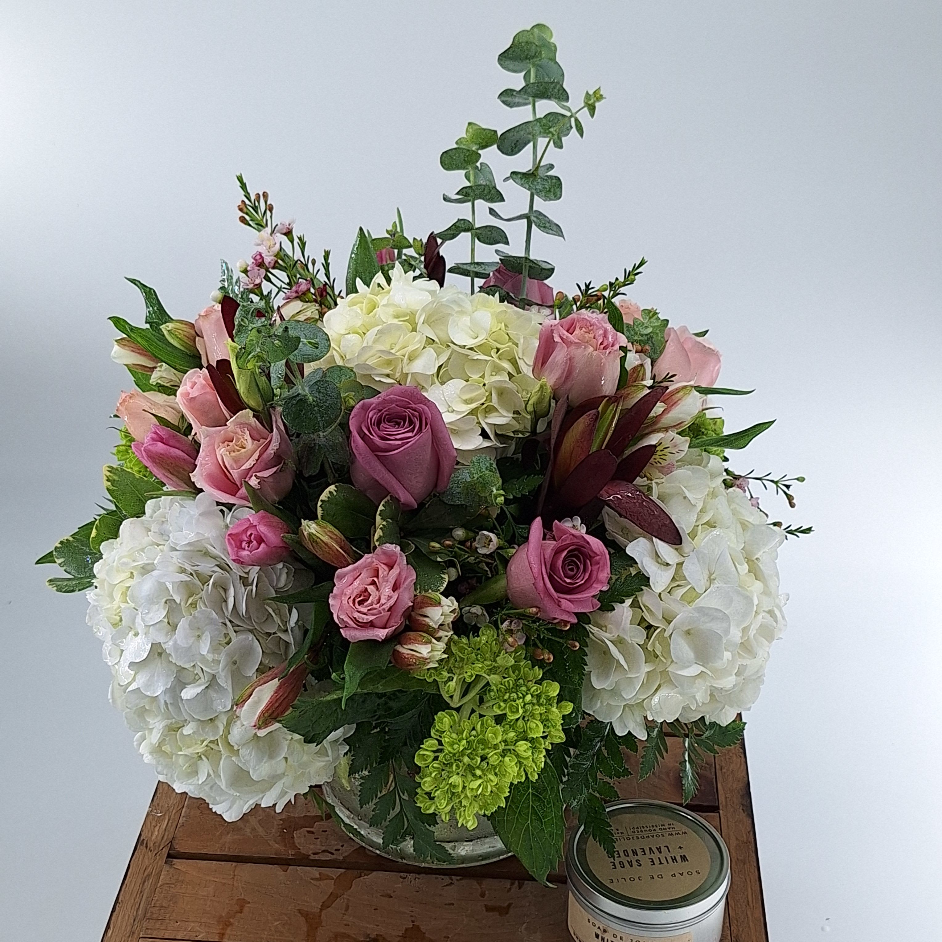 Pink roses and white hydrangeas in a low glass vase