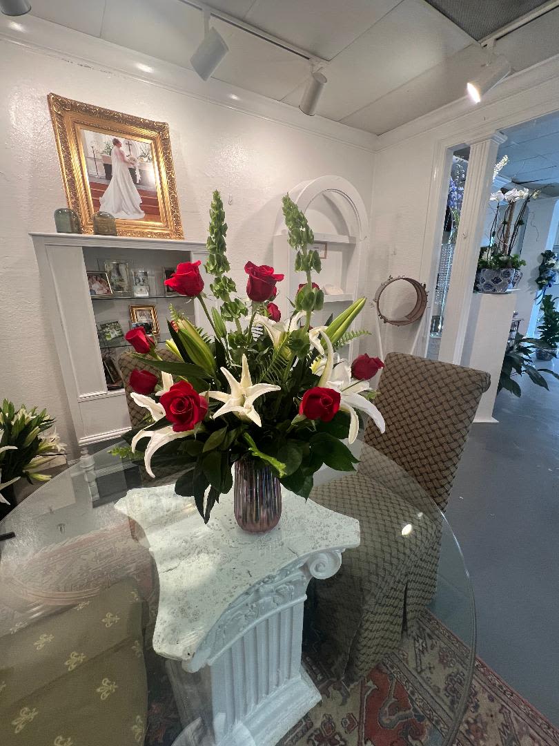 Red roses and white lilies arranged in a glass vase