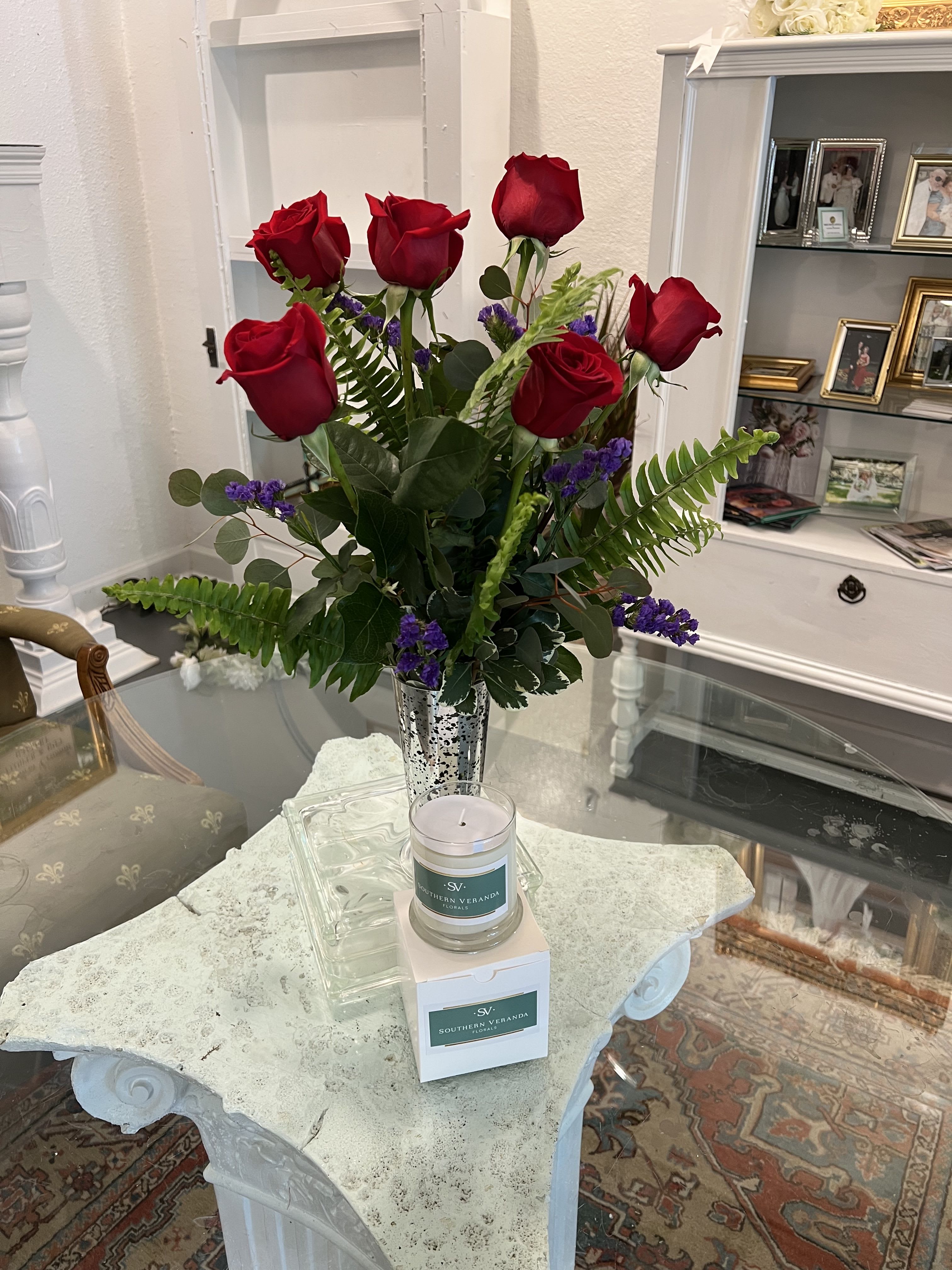 Red roses in a silver vase with purple filler flowers