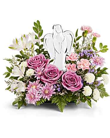 Pink and white floral arrangement with an angel figurine