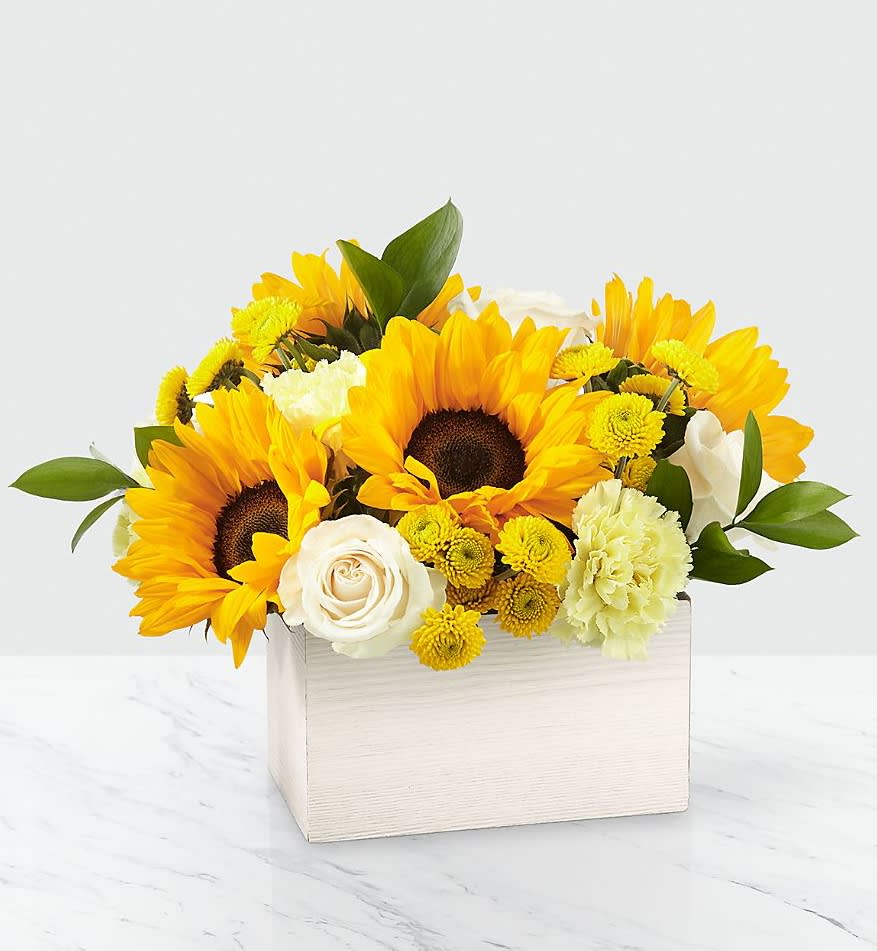 Sunflowers and white roses in a white wooden box