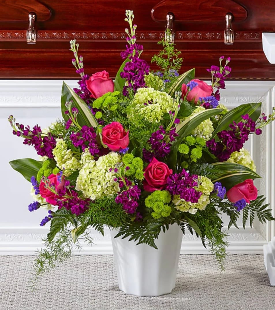 Pink roses and purple flowers in a white vase