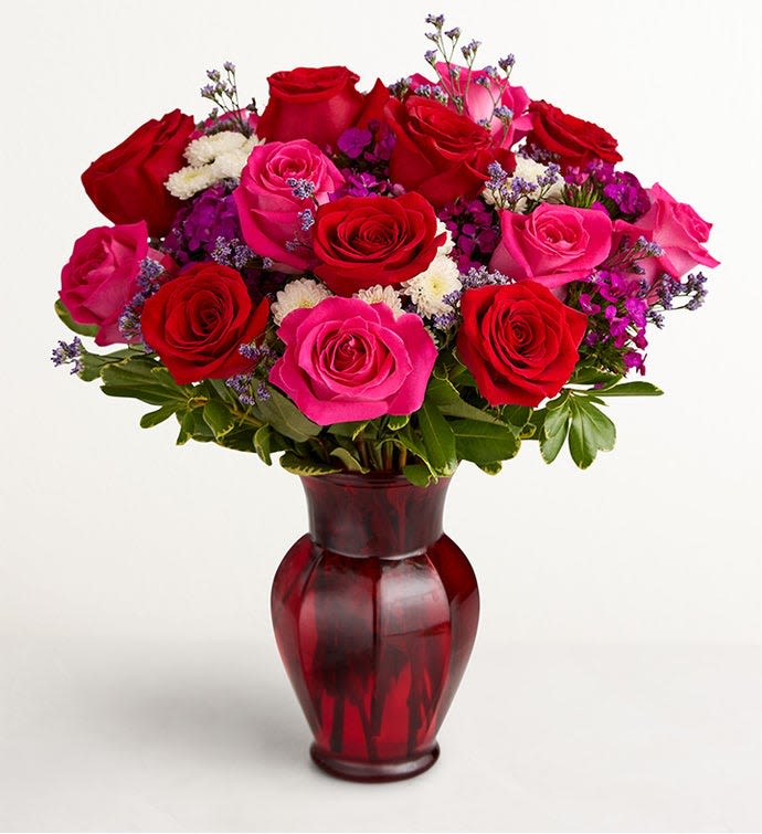 Bouquet of red and pink roses in a red glass vase