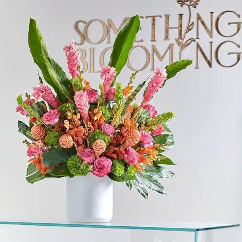 Tropical bouquet in a white vase with pink and orange flowers