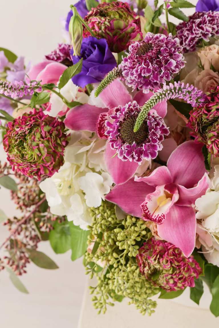 Bouquet of pink orchids, purple blooms, and white flowers