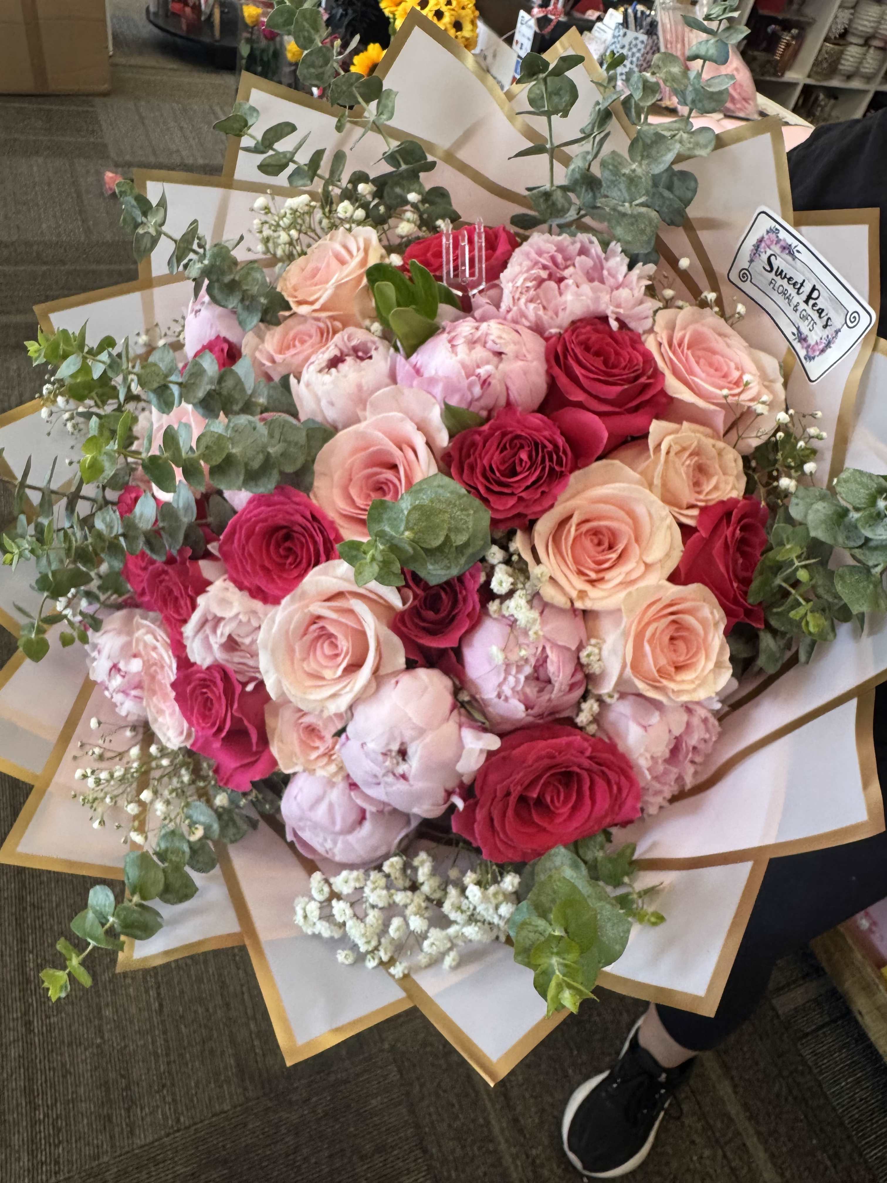 Hand-tied bouquet of pink and red roses with eucalyptus