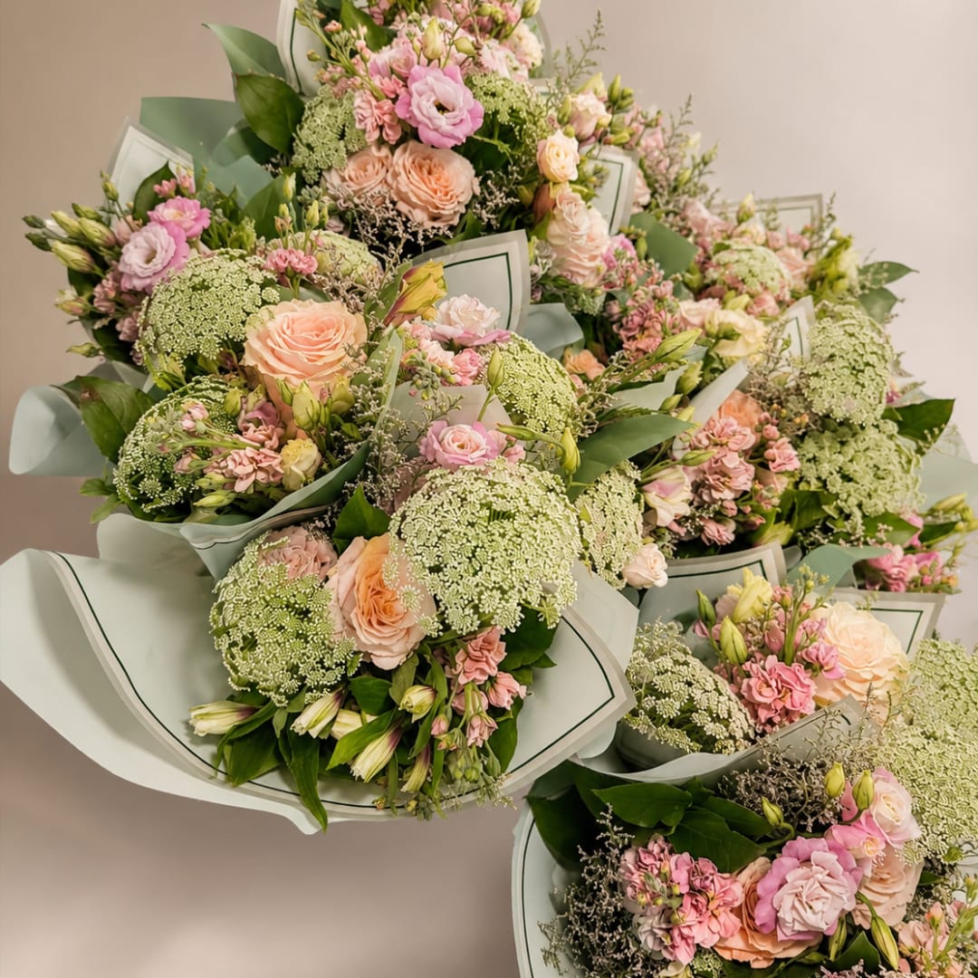 Bouquets of pink and peach roses with green filler flowers