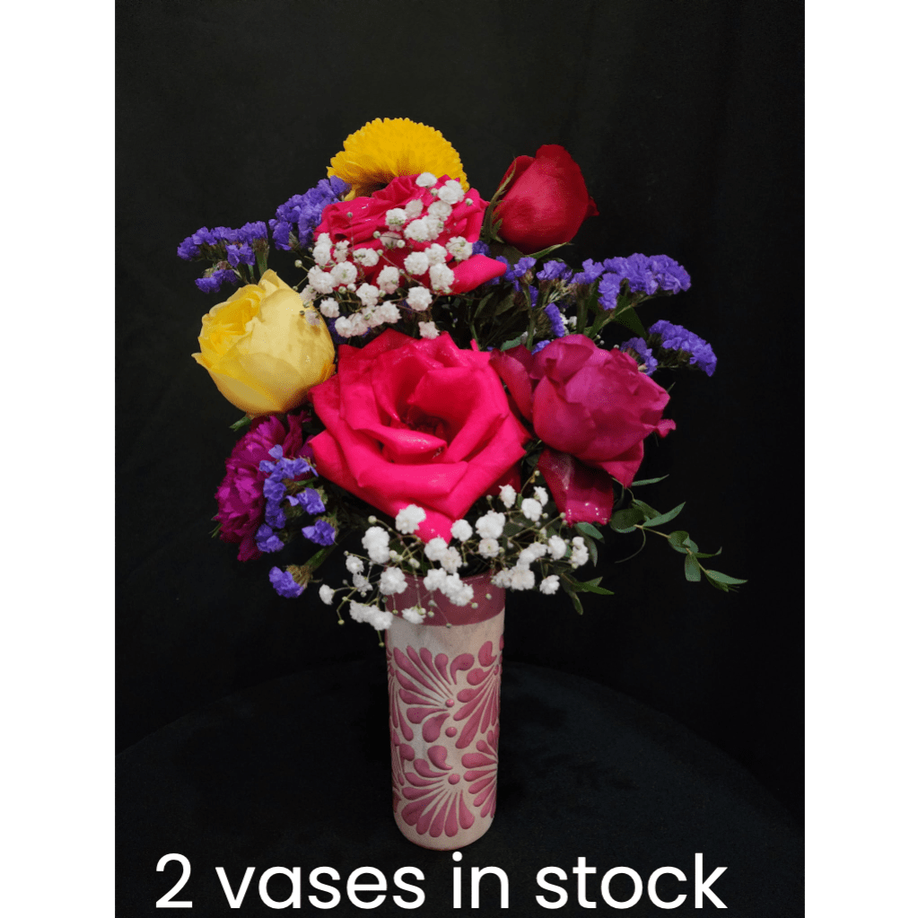 Colorful rose bouquet in a patterned vase against a black background