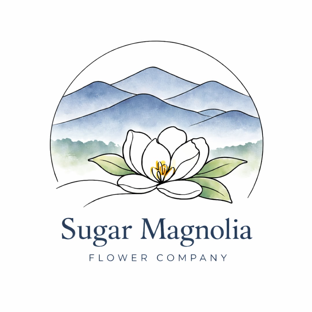 Sugar Magnolia Flower Company logo with a white magnolia and blue mountains