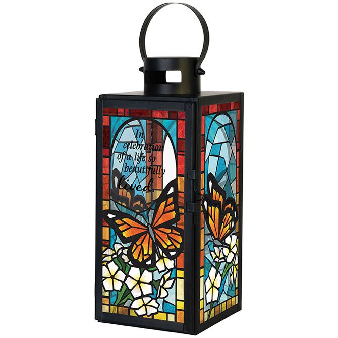 Decorative black lantern with stained-glass butterfly and flower panels