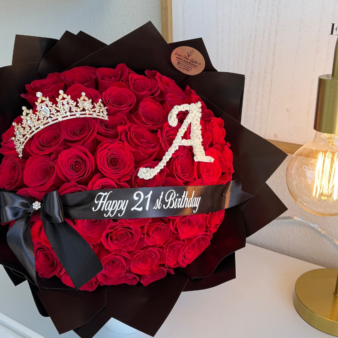 Heart-shaped bouquet of red roses with a crown and birthday ribbon