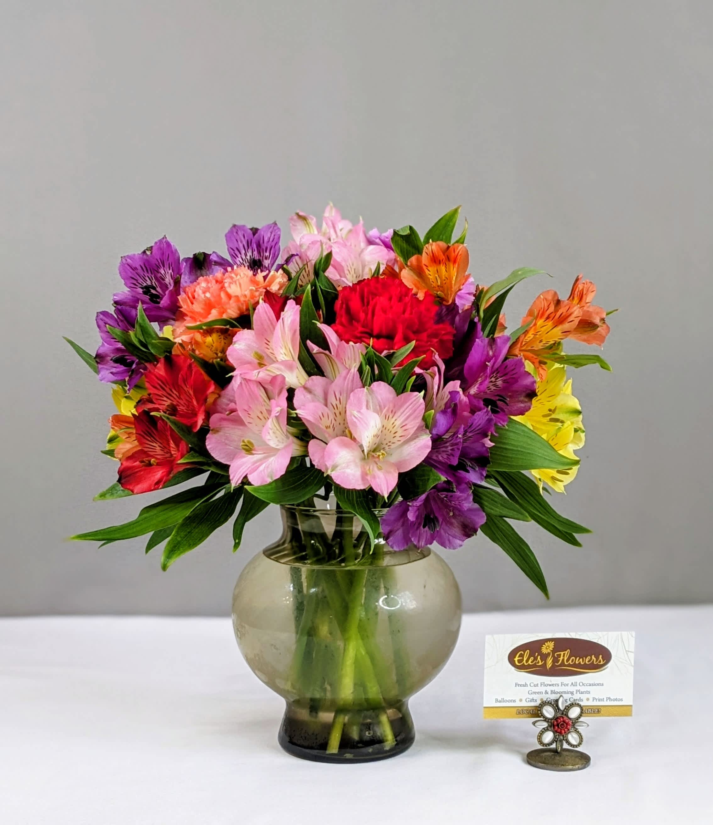 Colorful mixed bouquet in a round glass vase