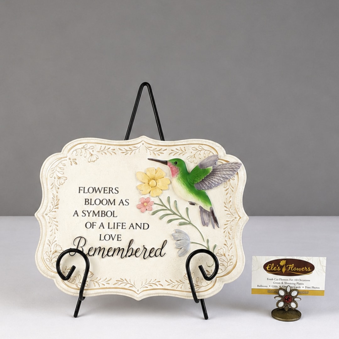 Decorative plaque with a hummingbird and flowers on a display stand