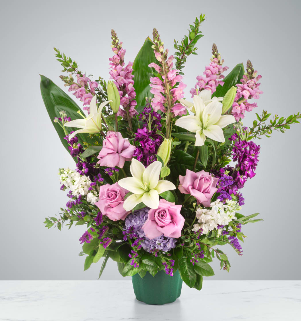 Purple Blessing  - A purple and white sympathy basket featuring snapdragons, roses, lilies, and stock. This fragrant arrangement works for every type of funeral ceremony.