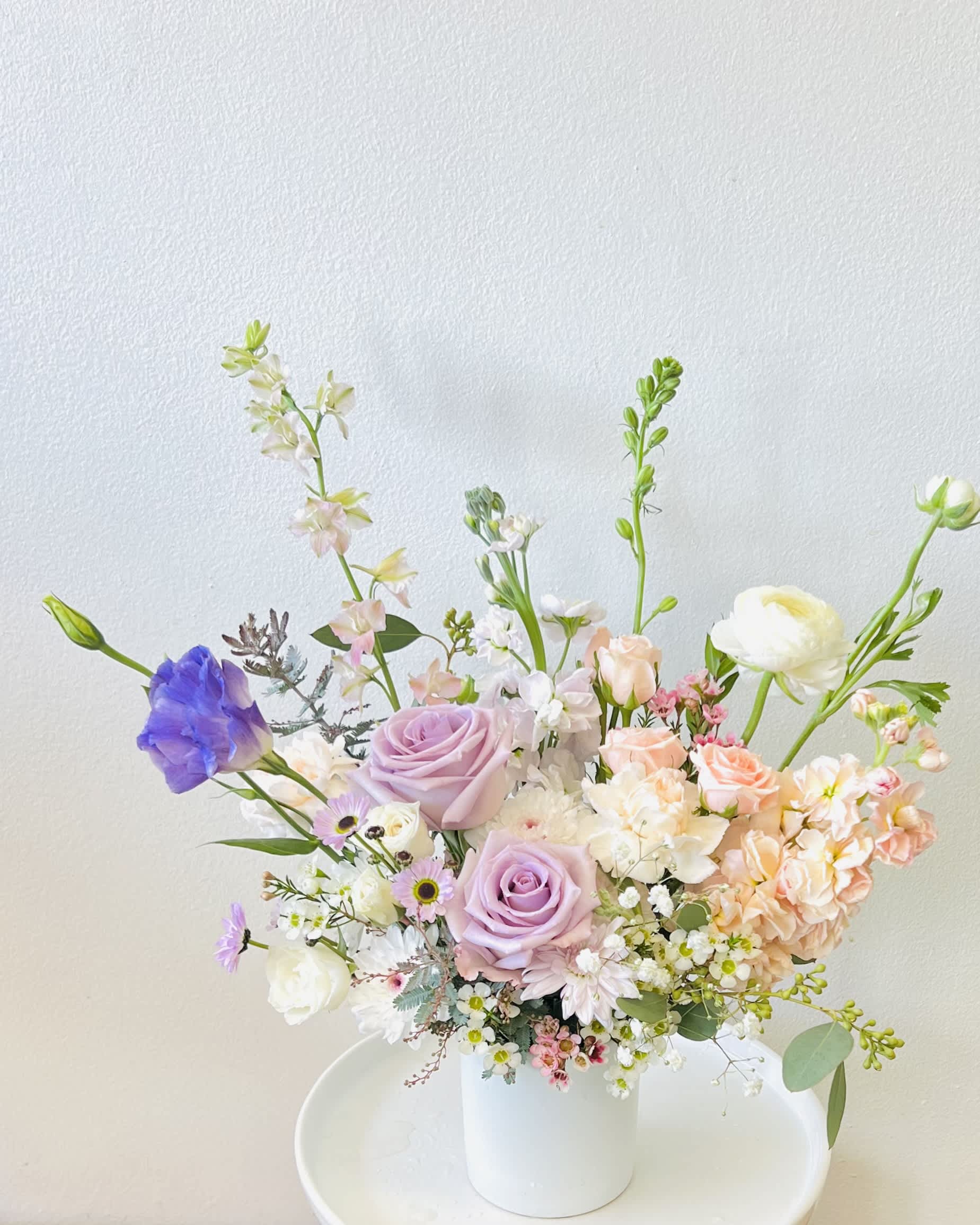 Purity Bloom  - Vase Arrangement  Store Hours Mon–Fri: 9:30 a.m. – 6:00 p.m. Sat: 9:00 a.m. – 4:00 p.m. Sun: Closed  Delivery Deliveries are typically made between 9:00 a.m. and 3:00 p.m. While we are unable to guarantee specific delivery times, we will always do our best to accommodate your requests. If you prefer a later afternoon delivery, please let us know in advance and we will try to accommodate. If your delivery address requires a gate code, please provide it to ensure smooth delivery.  Pick-Up If you need to pick up before 9:30 a.m., please text us directly to place your order. (Text: 714-715-1482) Please also try to pick up your order at the scheduled time. When pick-ups are delayed during busy time slots, it may affect other customers placing orders for the same time. We appreciate your understanding!  Please Note Your arrangement may vary slightly from the photos depending on seasonal availability and store stock. However, we will match the overall color palette and ensure your flowers are fresh and beautifully designed.  Thank you!!