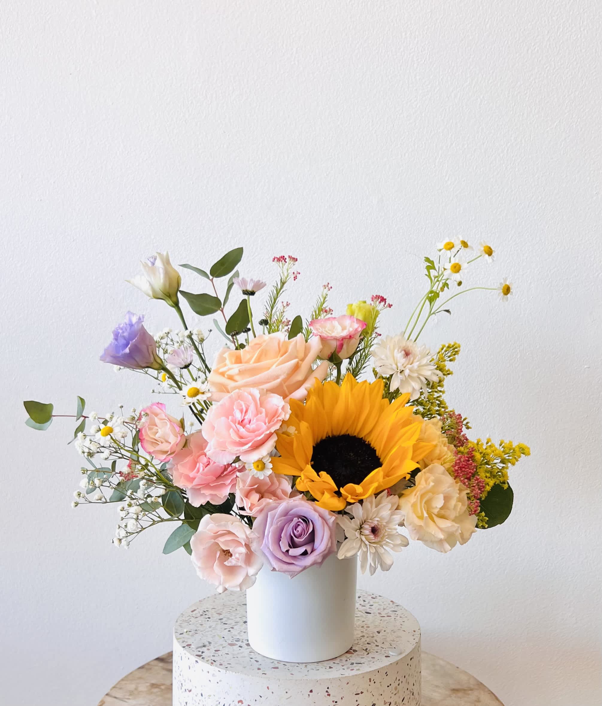 Sunlit Hills - Vase Arrangement  Store Hours Mon–Fri: 9:30 a.m. – 6:00 p.m. Sat: 9:00 a.m. – 4:00 p.m. Sun: Closed  Delivery Deliveries are typically made between 9:00 a.m. and 3:00 p.m. While we are unable to guarantee specific delivery times, we will always do our best to accommodate your requests. If you prefer a later afternoon delivery, please let us know in advance and we will try to accommodate. If your delivery address requires a gate code, please provide it to ensure smooth delivery.  Pick-Up If you need to pick up before 9:30 a.m., please text us directly to place your order. (Text: 714-715-1482) Please also try to pick up your order at the scheduled time. When pick-ups are delayed during busy time slots, it may affect other customers placing orders for the same time. We appreciate your understanding!  Please Note Your arrangement may vary slightly from the photos depending on seasonal availability and store stock. However, we will match the overall color palette and ensure your flowers are fresh and beautifully designed.  Thank you!!