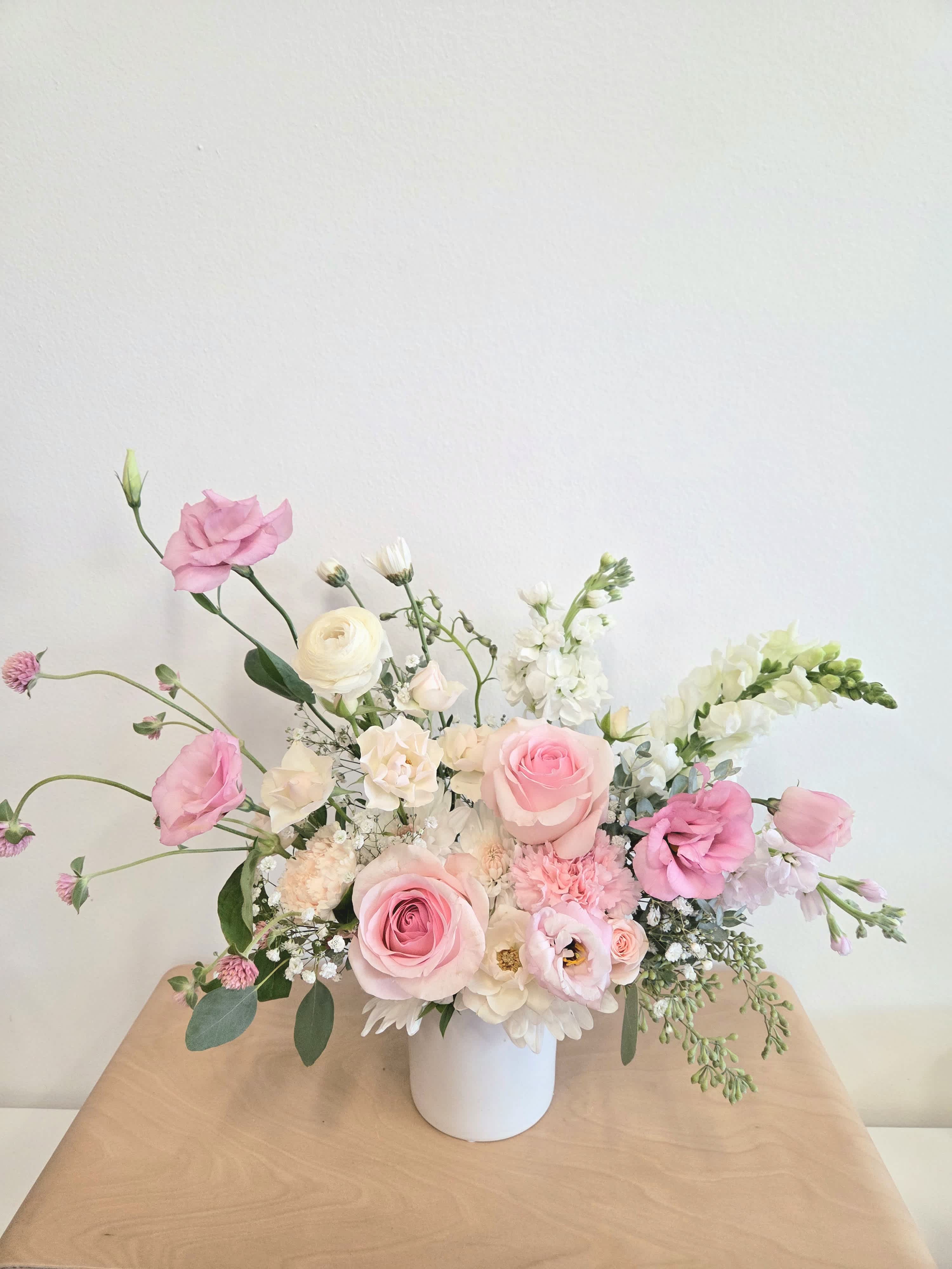 Pink and white floral arrangement in a white vase