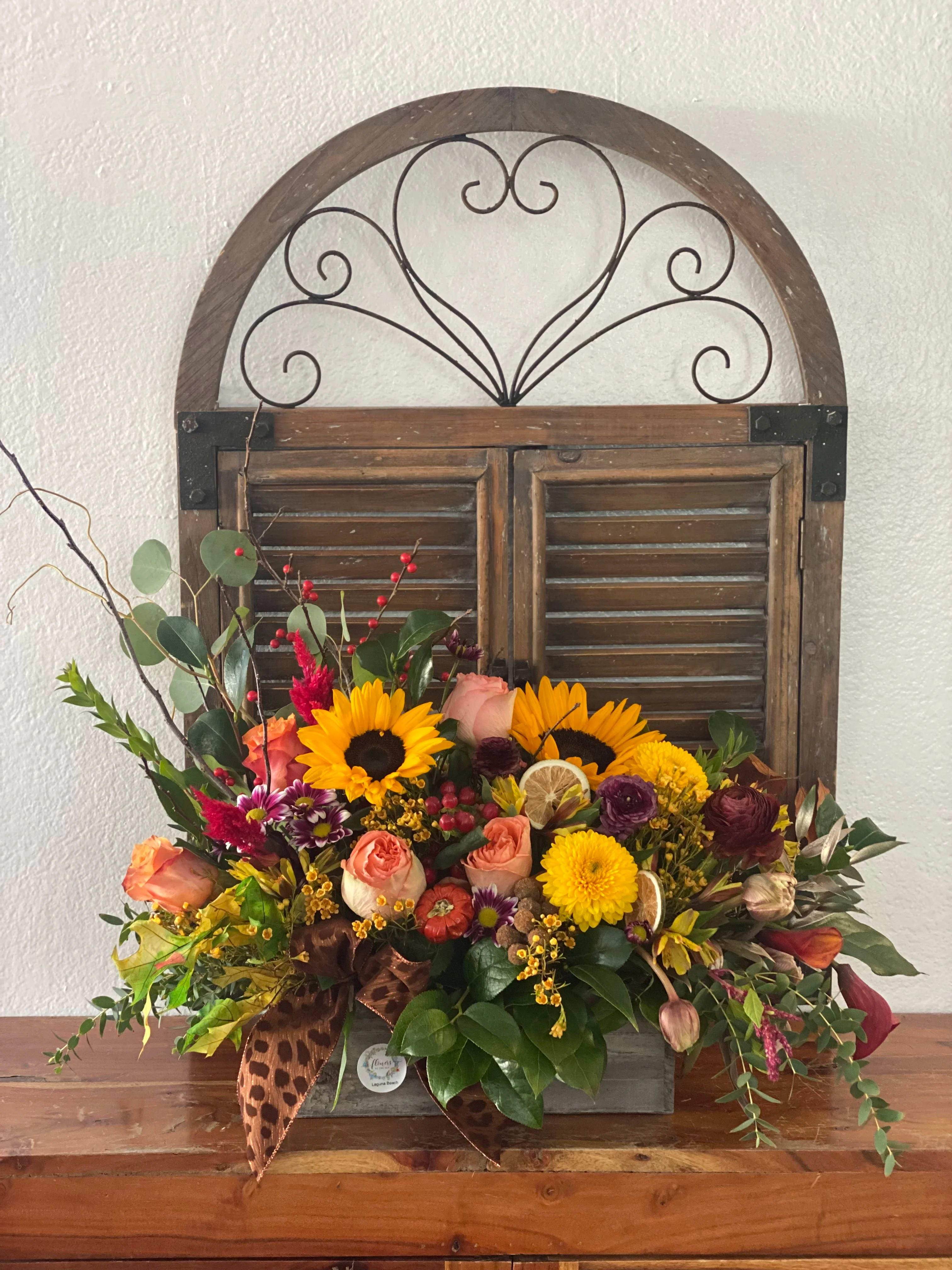 Mixed bouquet with sunflowers, roses, and mums in a wooden box