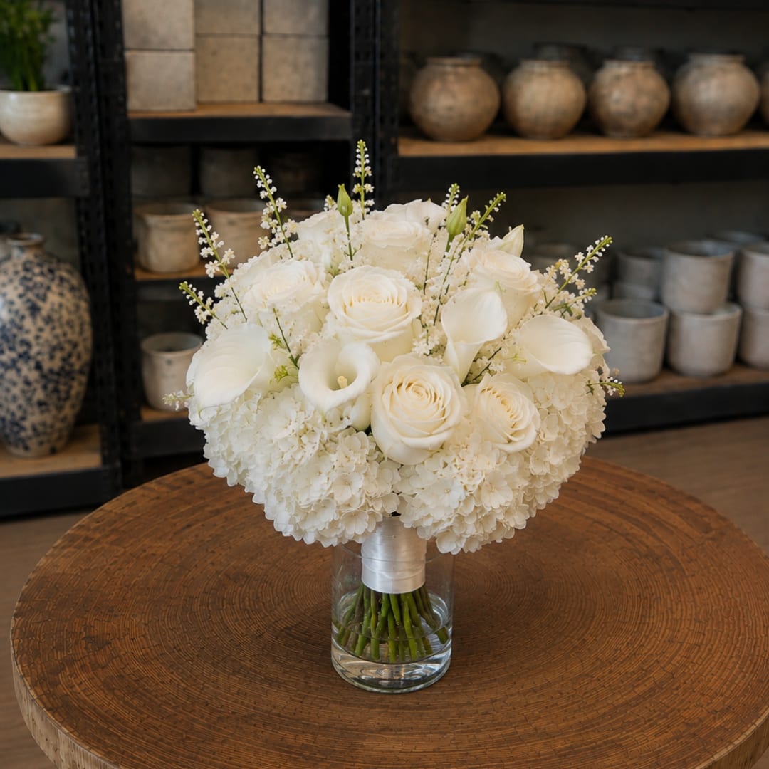 White roses and calla lilies in a glass vase