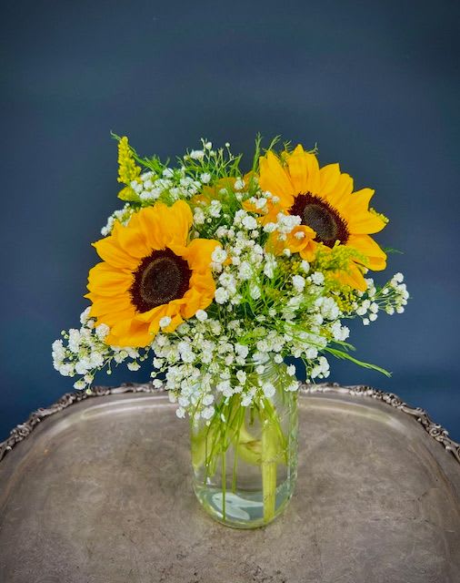 Sunflowers and white baby's breath in a clear glass vase