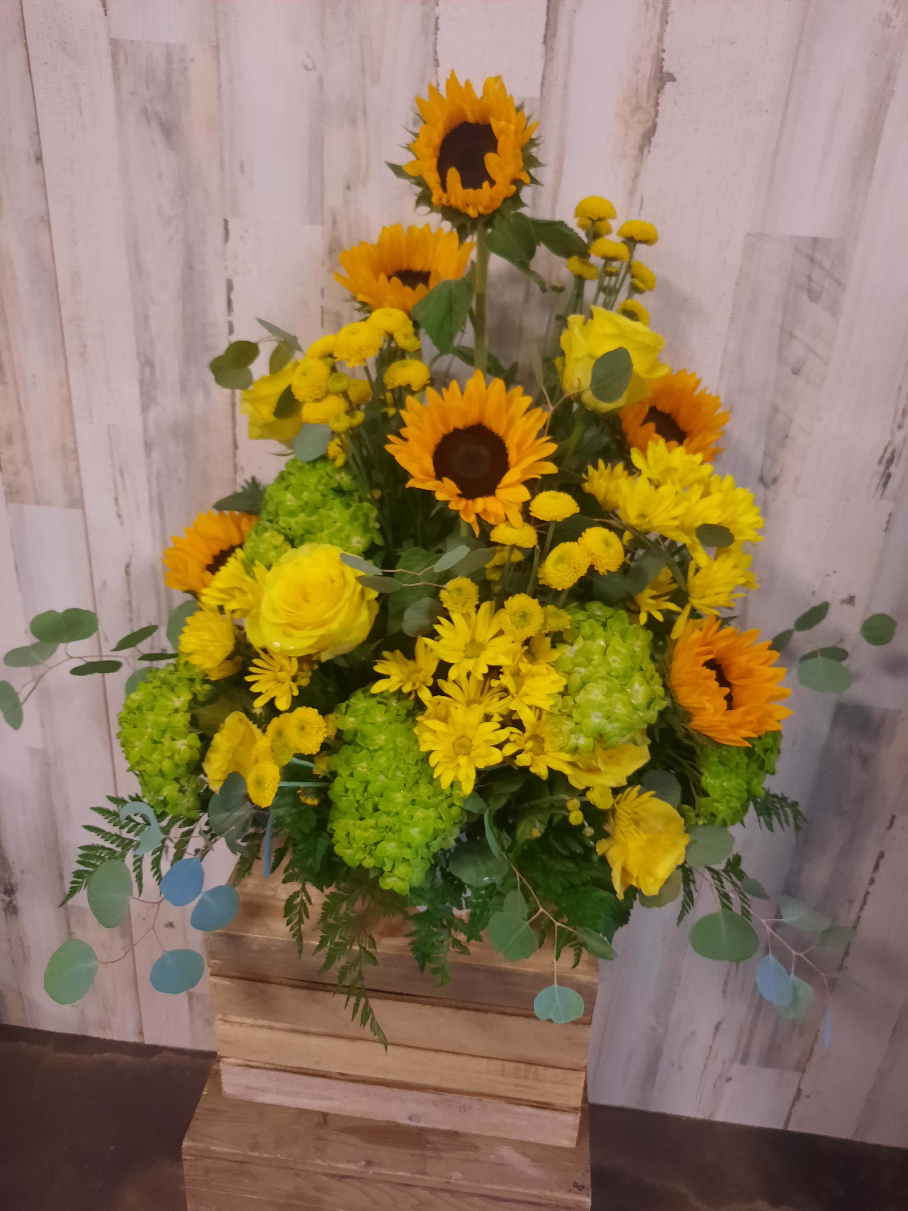 Yellow sunflower and rose arrangement in a wooden box
