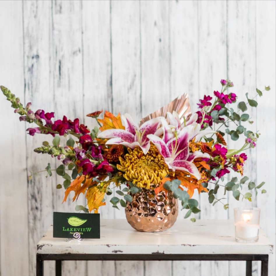 Bouquet of pink lilies and magenta flowers in a copper vase