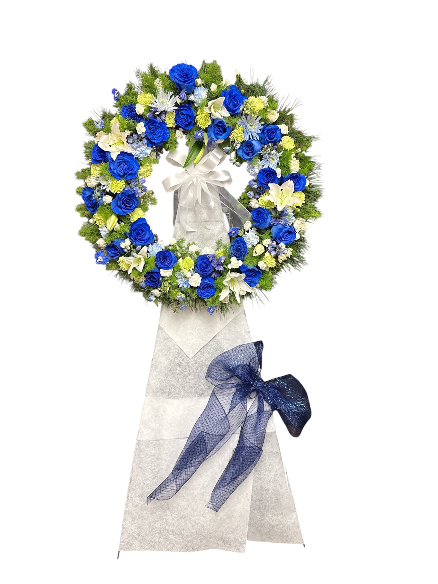 Blue and white floral funeral wreath on a stand with ribbon