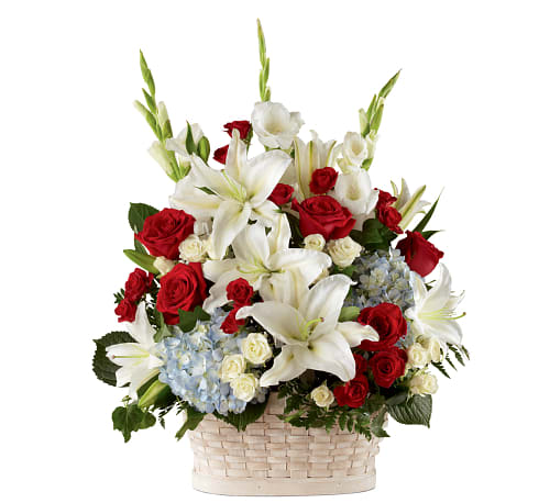Tall basket arrangement with white lilies, red roses, white roses, and light blue hydrangeas