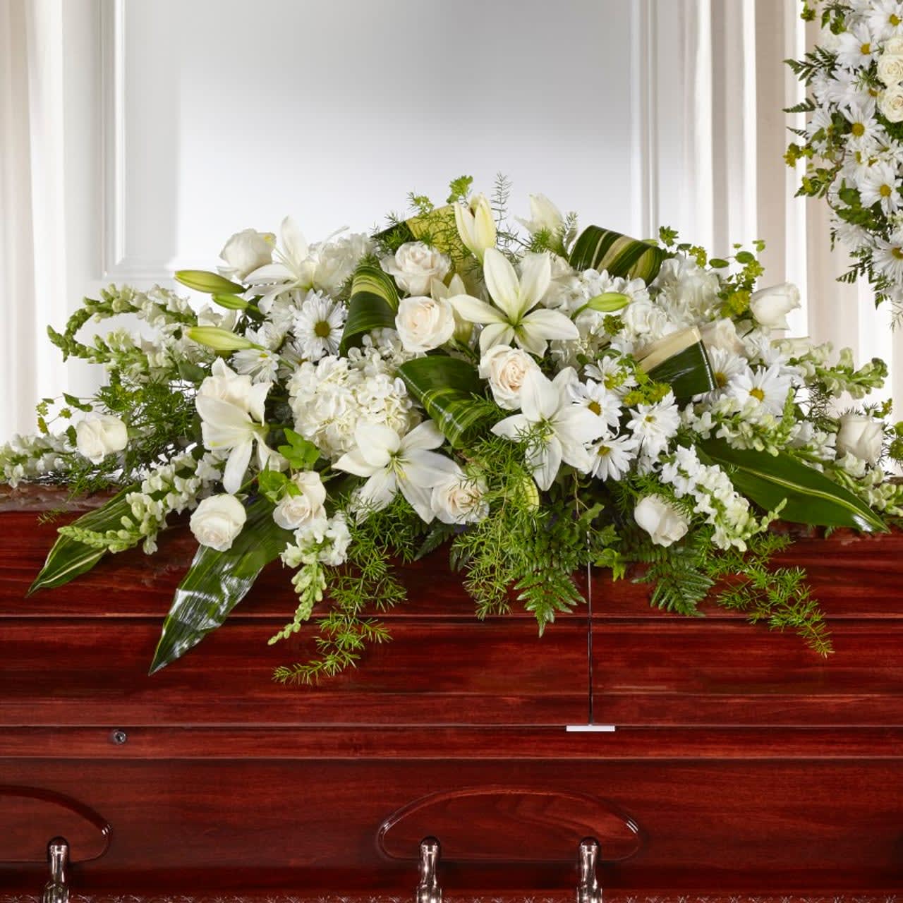 Serenity and Peace Casket Spray - Share serenity and peace with those who have recently lost a loved one with our Abundance™ Casket Spray. Composed of roses, snapdragons, lilies and hydrangea, this luminous collection of white and ivory hues comes together to create an elegant tribute. Spray is approximately 13"H x 49"W