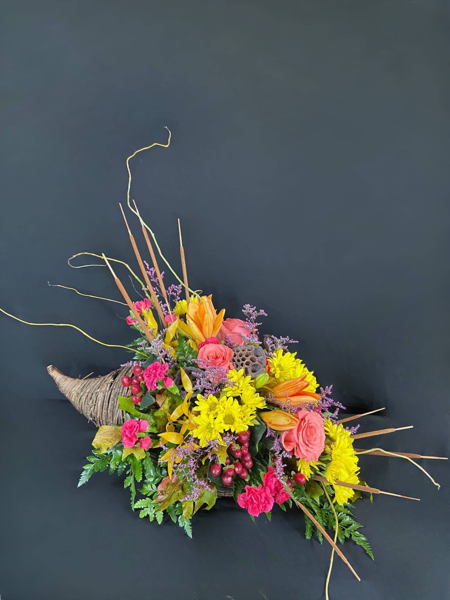 Colorful floral arrangement in a woven horn-shaped container