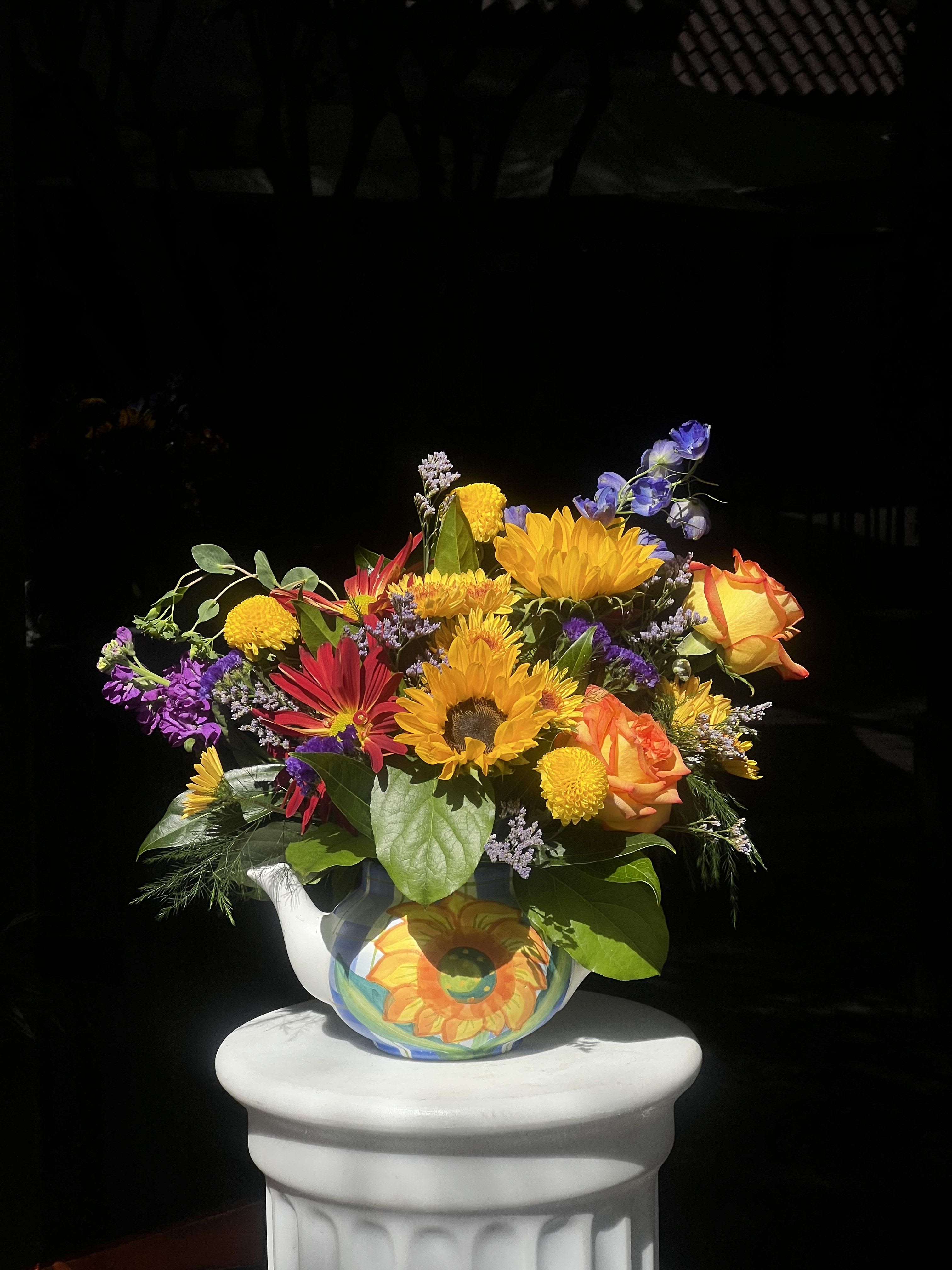 Bright mixed bouquet in a painted ceramic pitcher