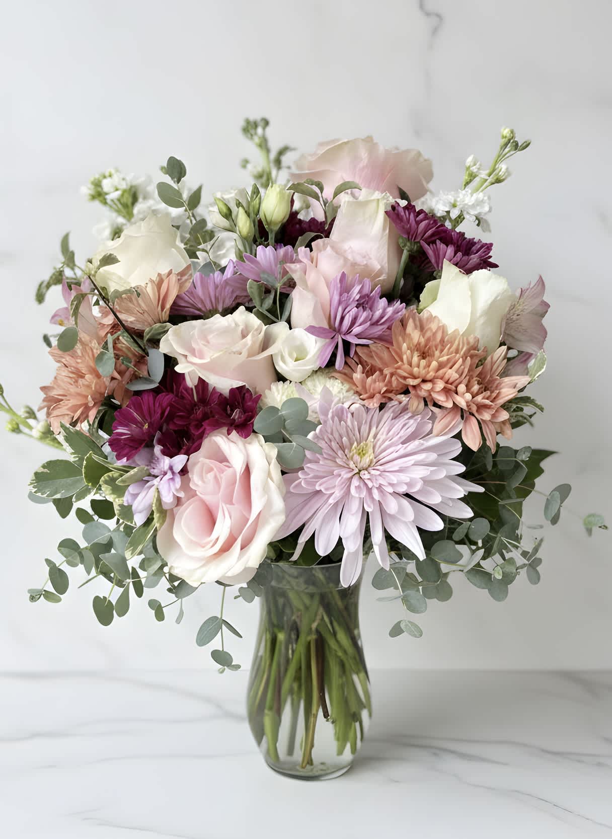 Pastel mixed flower bouquet in a clear glass vase