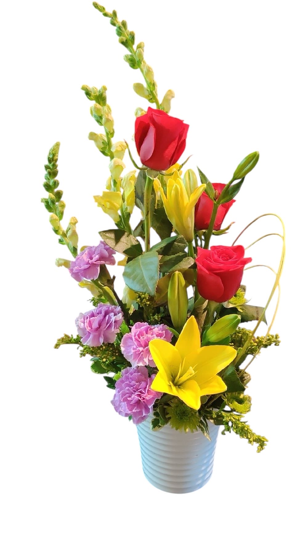 Tall mixed arrangement of red roses, yellow lilies, and purple carnations in a white pot